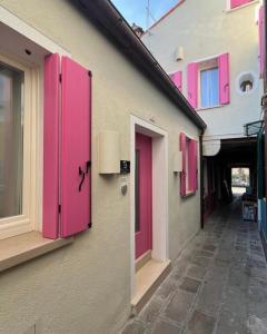 een rij roze deuren op een gebouw bij Vanessa Home in Burano