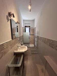 a bathroom with a sink and a mirror and a shower at Le Grotte di Notar in Castellana Grotte