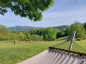 a bench in a field with mountains in the background at Martin's Family Cottage in Šmarje pri Jelšah