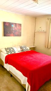 1 dormitorio con 1 cama grande con manta roja en Casa Pitanga - Abraão - IG, en Abraão