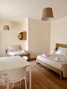 Habitación con 2 camas y mesa. en Fresia B&B, en Tuscania