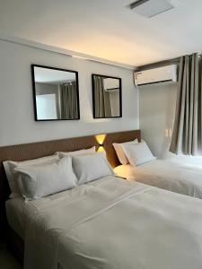 a hotel room with two beds and two mirrors at Gran Lençóis Barreirinhas Flat in Barreirinhas