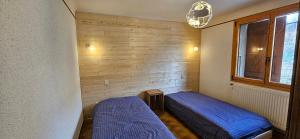 a bedroom with two beds and a window at Appartement de montagne à La LLagonne in La Llagonne