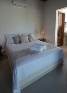 a white bed with two pillows on top of it at Chalé Macaúba in Santana do Riacho