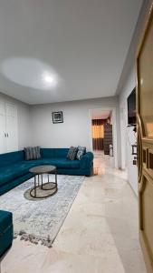 sala de estar con sofá azul y mesa en Chez-moi en Sfax