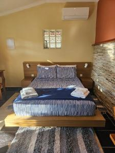 um quarto com uma cama grande e lençóis azuis em Suíte Verao em Maricá