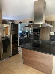 a large kitchen with black counters and stainless steel appliances at DIVO in Trans-en-Provence