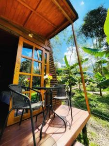 een patio met stoelen en een tafel op een veranda bij Yaque Glamping in San Francisco