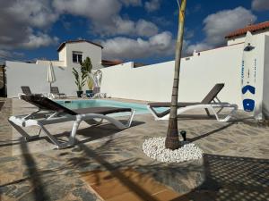 een zwembad met een palmboom en een chaise longue bij Villa Residencial El Guaidil in Triquivijate