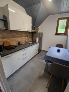 a kitchen with white cabinets and a table with a blue table cloth at U Eli in Korbielów