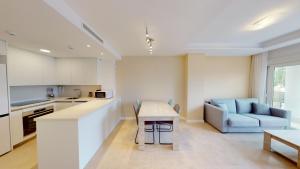 a kitchen and living room with a table and a couch at Edelweiss by ON Travel in Oliva