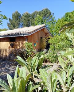 un pequeño edificio de madera en medio de un jardín en Maison de vacances 2 chambres plages lac à 600m proche Dune du Pilat Océan dans propriété privée, en Sanguinet