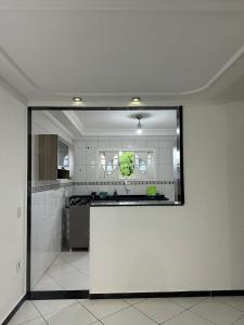 cocina con paredes blancas y espejo grande en Suíte Labirinto 01, en Saquarema