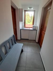 a small room with a bed and a kitchen at U Eli in Korbielów