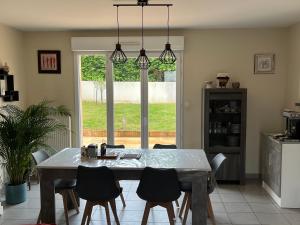a kitchen with a dining room table and chairs at Villa baba in Cholet
