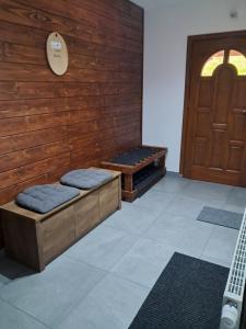 um quarto com dois bancos ao lado de uma porta de madeira em U Eli em Korbielów