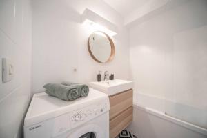 ein Badezimmer mit Waschmaschine und Waschbecken in der Unterkunft L'Amadéo - T2 Centre-ville & Parking in Clermont-Ferrand