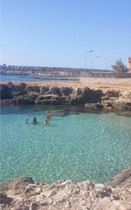 un grupo de personas nadando en un cuerpo de agua en Il Campo Blu, en Ognina