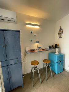 eine Küche mit einer blauen Theke und 2 Hockern in der Unterkunft L'Ostrica in Ostuni