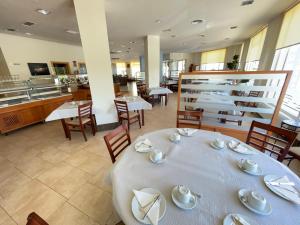Un comedor con una mesa y sillas blancas. en Hotel Playa Langosteira by Adeloló, en Finisterre