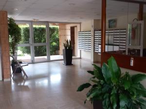 a lobby with potted plants in a building at Les dunes de Nauzan in Vaux-sur-Mer