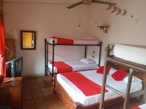 a room with two bunk beds and a tv at Hotel Viajero Mompox in Mompos