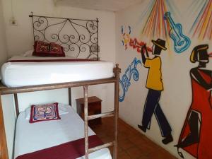 una camera da letto con un letto e un dipinto sul muro di Hotel Viajero Mompox a Mompós