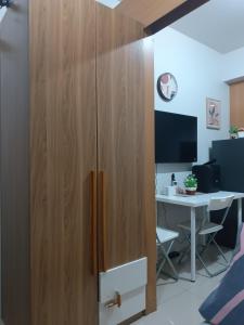 een grote houten kast in een kamer met een bureau bij Shell Residences condotel Staycation in Manilla