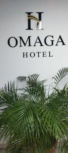 a sign for a morocco hotel with a green plant at Suite Gold Hotel Omaga in El Peñol