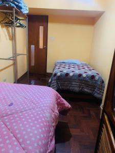 a room with two beds and a bunk bed at Ukumari Hostel in Cusco