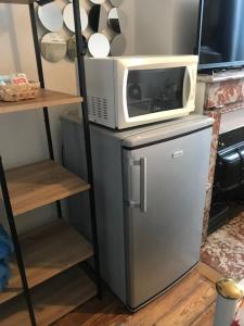 a microwave sitting on top of a refrigerator at vaste chambre familiale in Bourg-en-Bresse