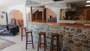 a living room with a stone bar and stools at Superbe logement 12 pers famille ou groupe. in Laruns