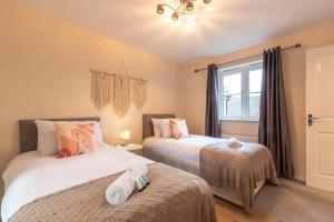 um quarto com 2 camas e uma janela em 3-Bedroom Home in Peterborough with Free Parking & Netflix by HP Accommodation em Peterborough