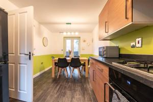 uma cozinha com mesa e cadeiras num quarto em 3-Bedroom Home in Peterborough with Free Parking & Netflix by HP Accommodation em Peterborough