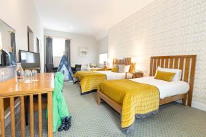 マララニーにあるMulranny Park Hotelのベッド2台とテレビが備わるホテルルームです。