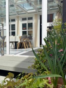 un porche con plantas, mesa y sillas en Hotel Garni Brugger, en Lindau