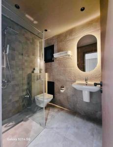 a bathroom with a sink and a toilet and a mirror at Une véritable perle rare in Sfax