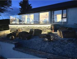a house with rocks in front of a building at Nan's Place Donegal - New Renovation with stunning Views in Lettermacaward