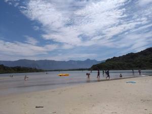a group of people playing on the beach at Bertioga Praia Guaratuba - Condomínio Costa do Sol in Bertioga