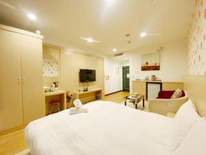 a bedroom with a white bed and a living room at 85海洋之星 in Ta-lin-wei