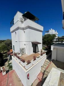 a white building with potted plants on top of it at PLEASENT SUNSET in CESME-SITE SOLEY 17 in Çeşme