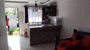 eine Küche mit einer Theke und eine Person steht in der Küche in der Unterkunft Precious Home stays in Maragoli