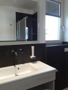 y baño con lavabo y espejo. en Hotel Danieli La Castellana lago di Garda, en Brenzone sul Garda