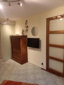 a living room with a television and a door at LE CLOS DE GRIGNON in Thiverval-Grignon +11 photos