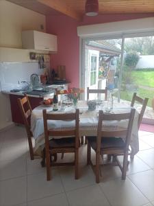 a kitchen with a table with chairs and a table and a window at LE CLOS DE GRIGNON in Thiverval-Grignon