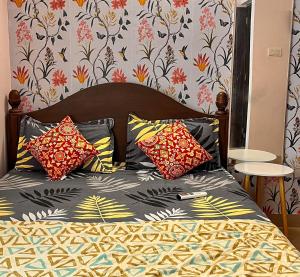 a bedroom with a bed with colorful pillows at Pebbles 2BHK Home By Goaround Homes in Siolim