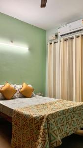 a bedroom with a bed with yellow pillows on it at Pebbles 2BHK Home By Goaround Homes in Siolim