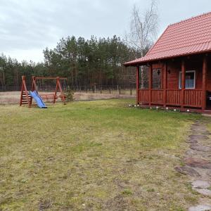 a playground with a house and a slide at Domek u Natalii 