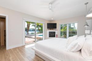 1 dormitorio blanco con 1 cama grande y chimenea en Tropical Waterfront Family Oasis - Amazing Location, en Miami