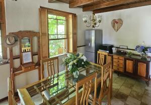 a kitchen with a glass table with chairs and a refrigerator at Rawsonville House in Rawsonville